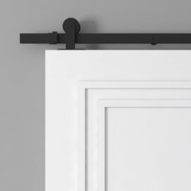 A close-up of the upper section of a white barn door with a black sliding hardware track mounted on a grey wall.