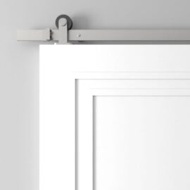 Close-up view of a white sliding barn door with a gray rail system attached to a light gray wall.