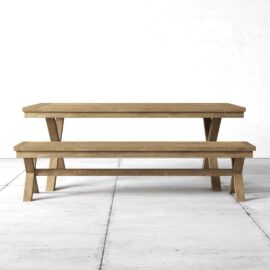 Wooden dining table and matching bench on a concrete floor against a white wall.