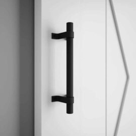 The 13th Street Barn Door Handle is mounted on a white door with a geometric design.