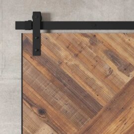 A close-up of the Malibu Barn Door, made from rustic wooden panels and mounted on a black metal track against a gray wall.