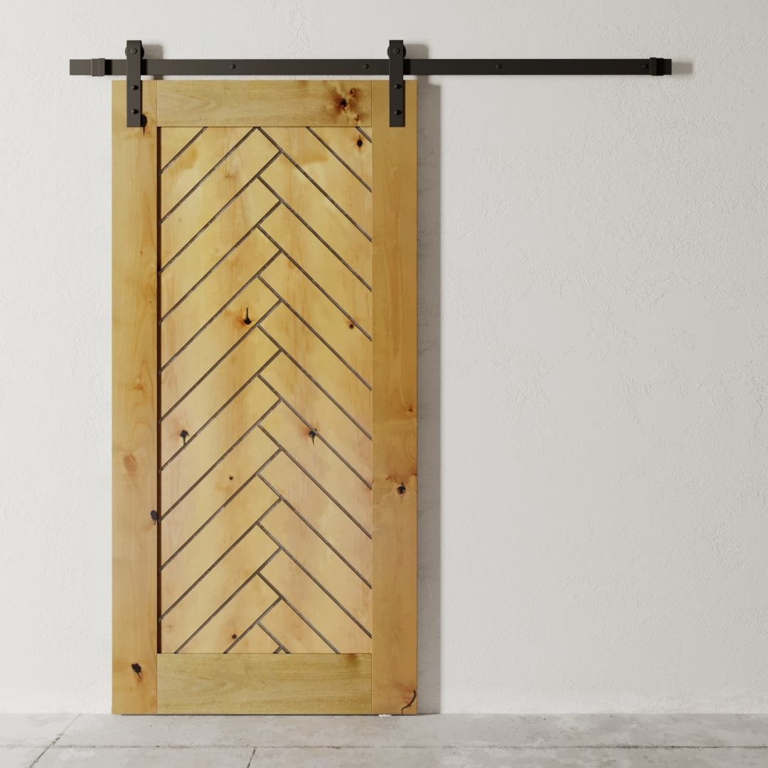 The Nuvo 83" x 40" Barn Door, featuring a chevron pattern and dark metal hardware, is mounted on a white wall above a light grey floor.