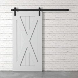 The X-Panel Barn Door, featuring a white barn-style design with black hardware, is installed on a white brick wall.