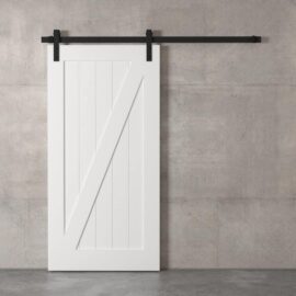 A Z-Panel Barn Door with black hardware is mounted on a plain gray concrete wall.