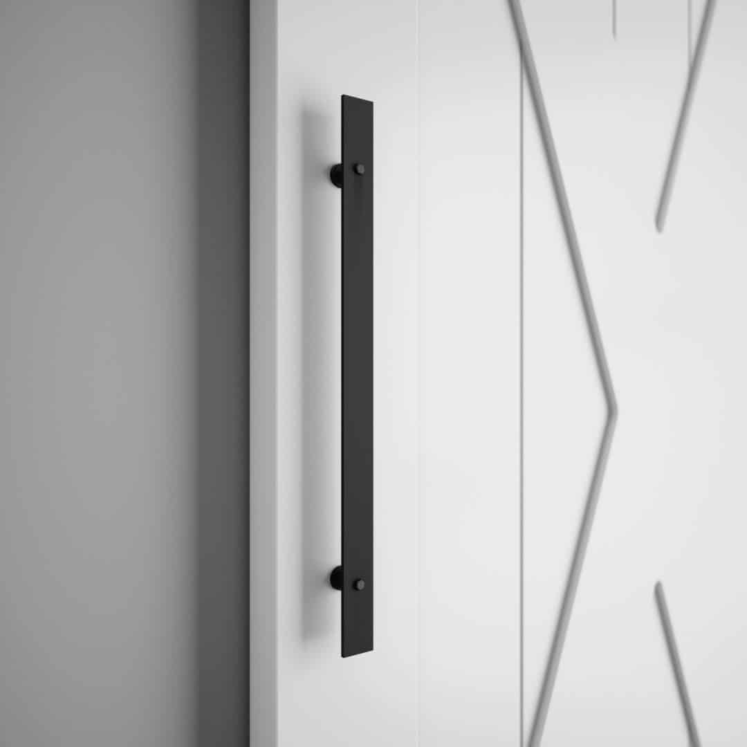 A close-up of the 18th Street Barn Door Handle in black, mounted on a white door featuring a geometric design.