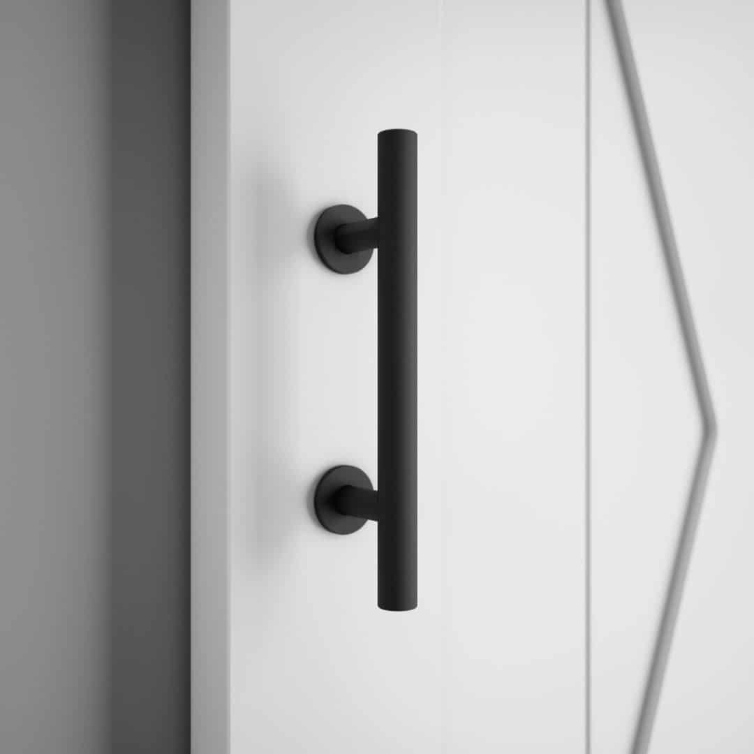 A close-up of the 19th Street Barn Door Handle 2 Sided, featuring a sleek cylindrical design in black, mounted on a white door.