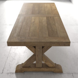 A Madera Dining Table - Natural with a rustic design, featuring a rectangular top and an X-shaped base, placed on a smooth floor in a bright room.