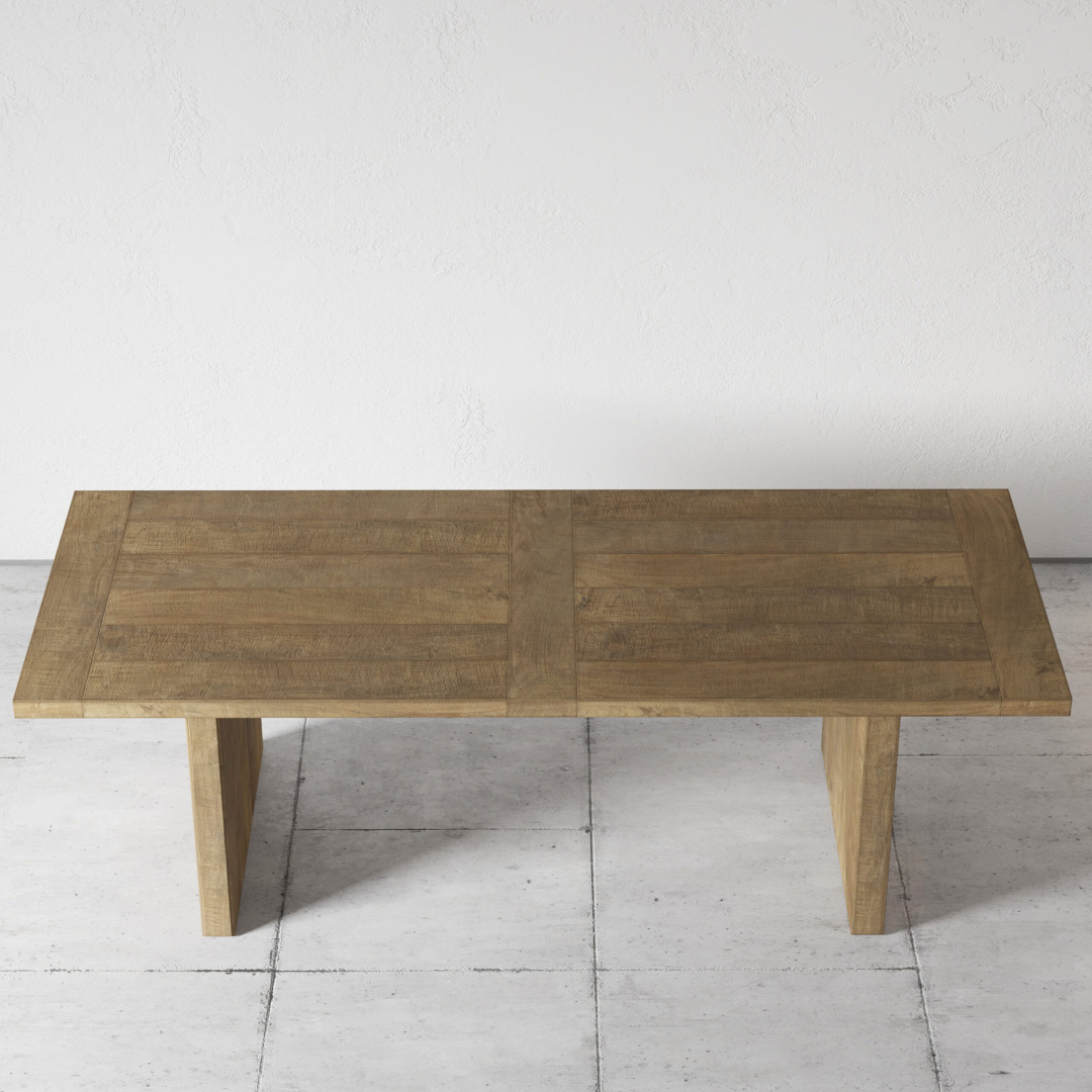 Camden 96 table teak 2 The Camden Dining Table, featuring a light brown finish and a wooden rectangular design, stands on a light gray tiled floor against a plain white wall.