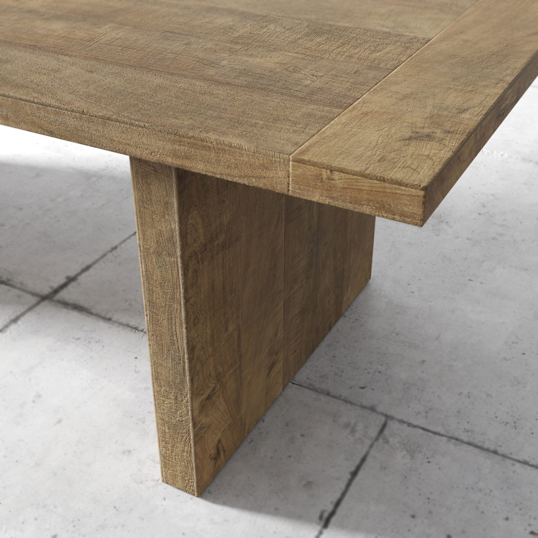 Camden 96 table teak doof Close-up view of the Camden Dining Table with a thick, sturdy leg set on a tiled floor. The table has a natural wood finish with visible grain patterns.