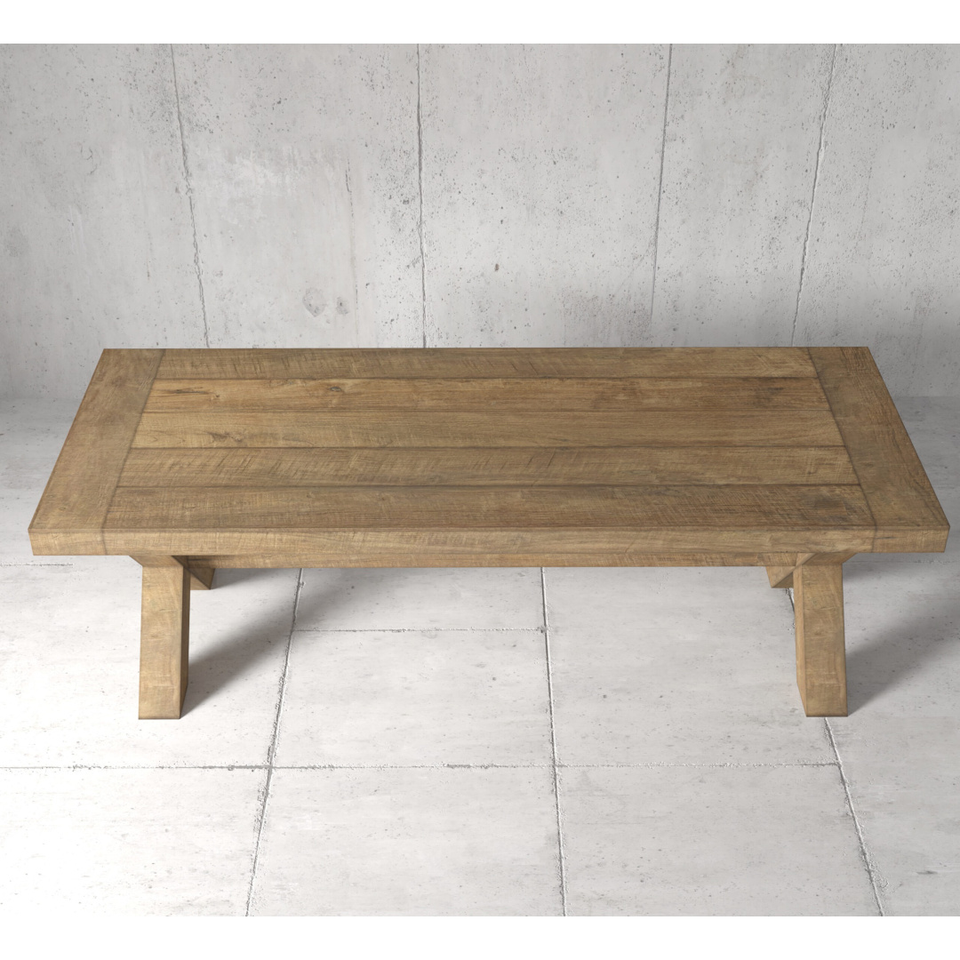 GRAND CROSS 3 The Grand Cross Dining Table, a wooden rectangular piece with thick legs, stands on a tiled floor against a concrete wall background.