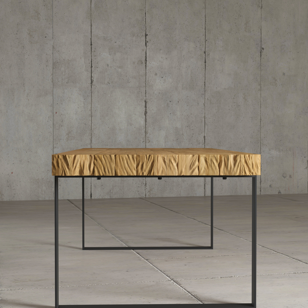 HUDSON DINING TABLE - 2 The Hudson Dining Table, featuring a wrinkled yellow fabric top and black metal legs, stands on a concrete floor against a concrete wall.