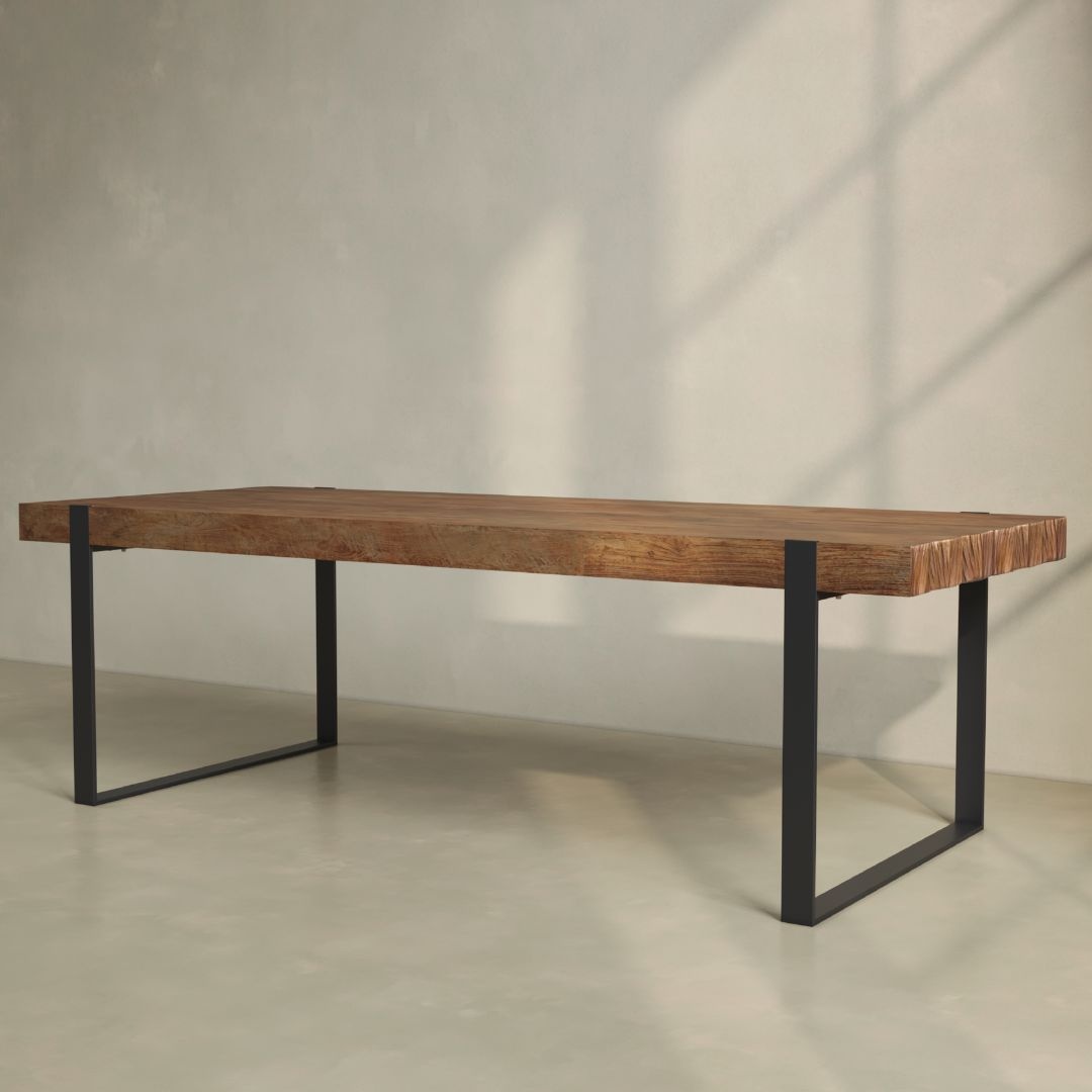 The Hudson Dining Table features a thick, natural wood top paired with sleek black metal legs, set against a simple, light-colored background.