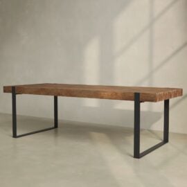The Hudson Dining Table features a thick, natural wood top paired with sleek black metal legs, set against a simple, light-colored background.