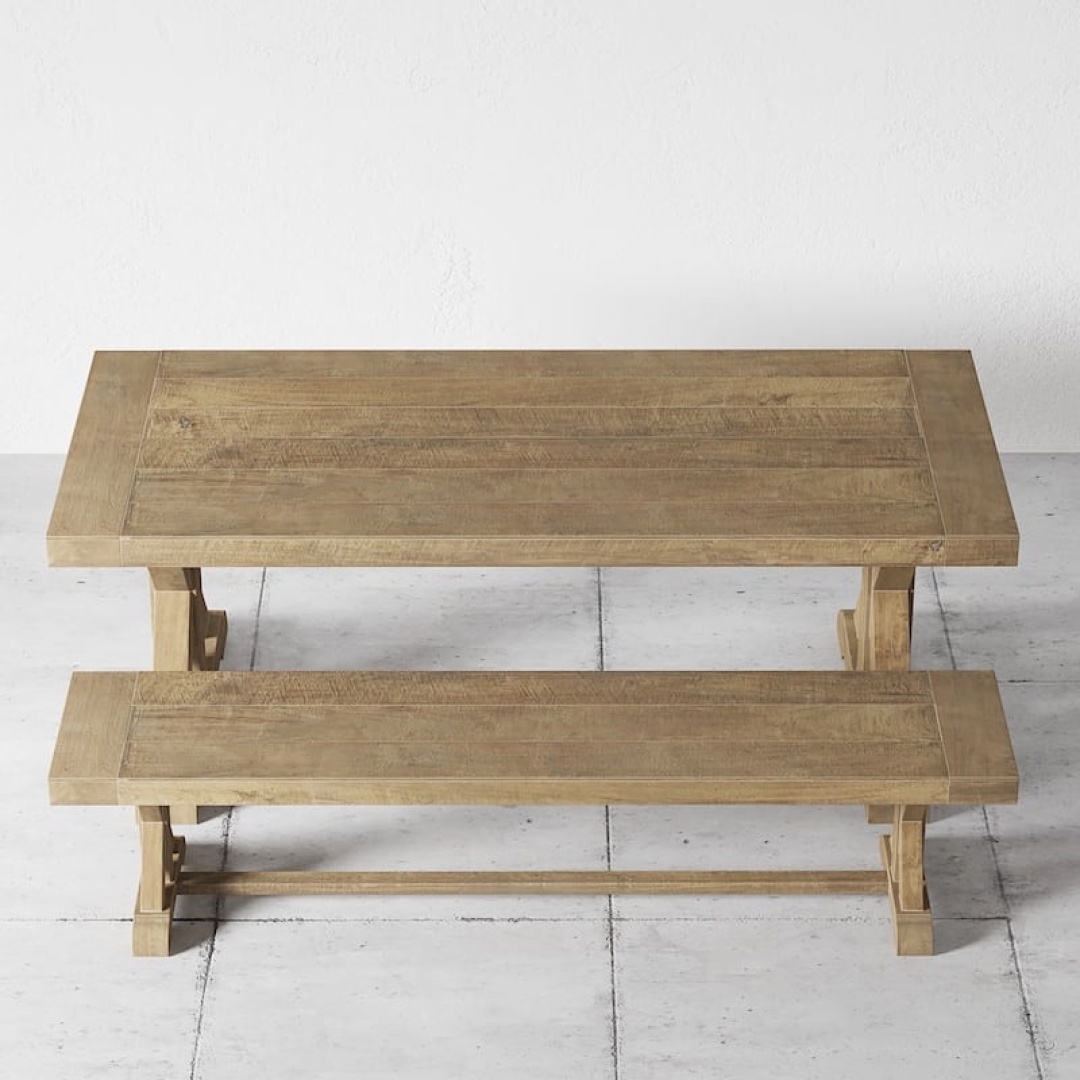 The Madera Dining Bench paired with a wooden dining table on a tiled floor against a plain white wall.