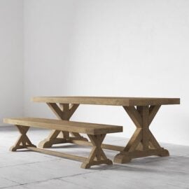 A Madera Dining Bench and matching wooden dining table, both featuring X-shaped legs, set against a plain white background.