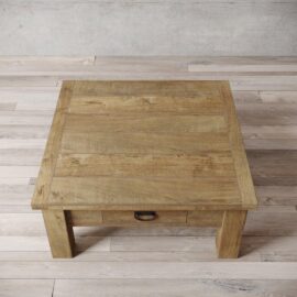 A top-down view of the Riverbend Coffee Table, a rectangular wooden coffee table featuring a single drawer, positioned on a light wooden floor against a gray wall.