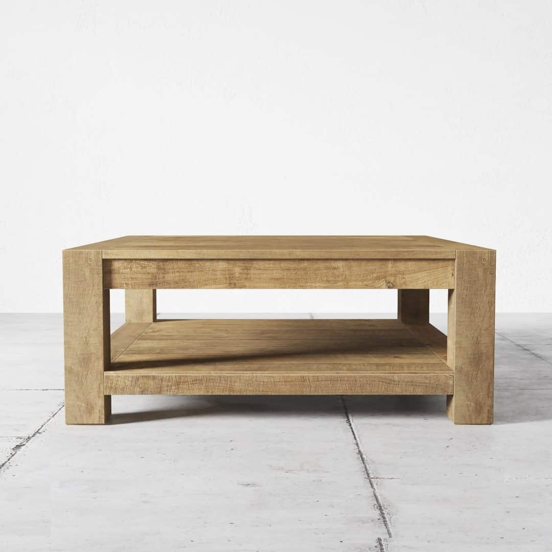 The Villa Coffee Table, a rectangular wooden piece with a lower shelf, is elegantly stationed on a light-colored tiled floor.