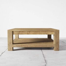 The Villa Coffee Table, a rectangular wooden piece with a lower shelf, is elegantly stationed on a light-colored tiled floor.
