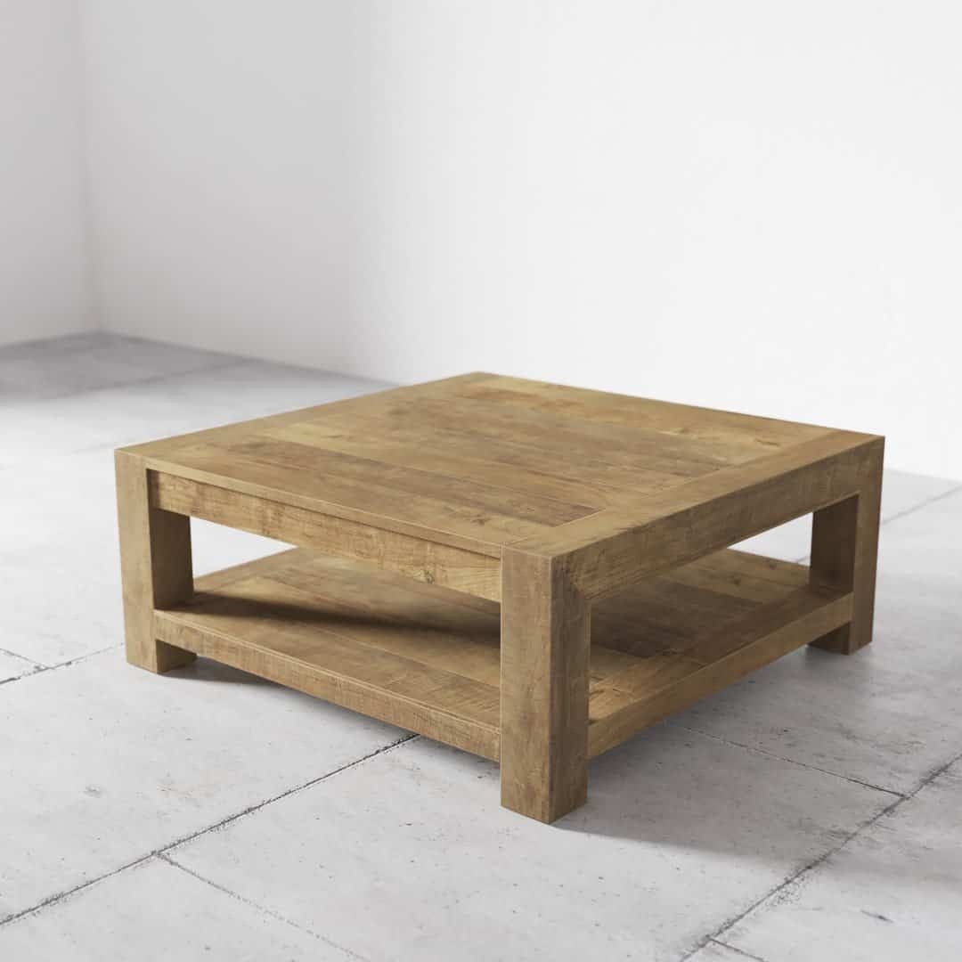 The Villa Coffee Table, with its square wooden design and an additional shelf underneath, is placed on a light gray tiled floor against a white wall.