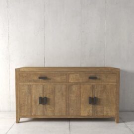 The Brookside Dining Buffet, a wooden sideboard with two drawers at the top and two cabinets below, featuring black metal handles, is set against a plain concrete wall.