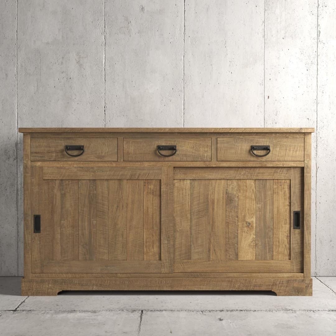 The Riverbend Sliding Door Dining Buffet, featuring three drawers and two sliding doors, stands against a textured concrete wall.