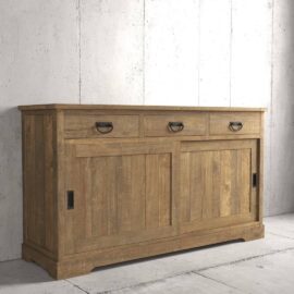The Riverbend Sliding Door Dining Buffet, with its rustic design featuring three drawers and two sliding doors, is beautifully placed against a concrete wall.