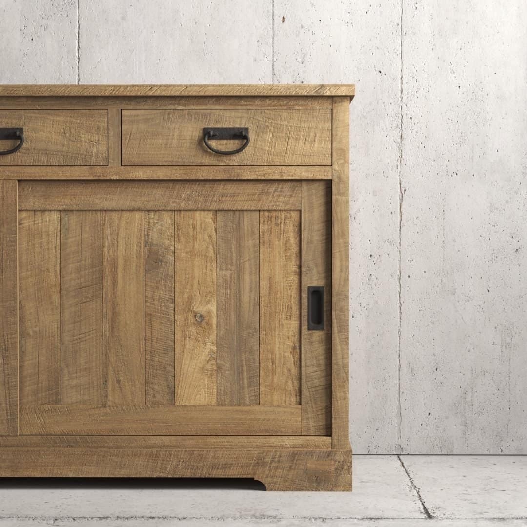 Urban Woodcraft 65 Riverbend Dining Buffet - Natural (4) The Riverbend Sliding Door Dining Buffet stands against a gray concrete wall, featuring a rustic wooden design with two drawers and one cabinet door.