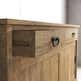 The Riverbend Sliding Door Dining Buffet features a wooden sideboard with a rustic finish and black metal handles, with the top drawer slightly open.
