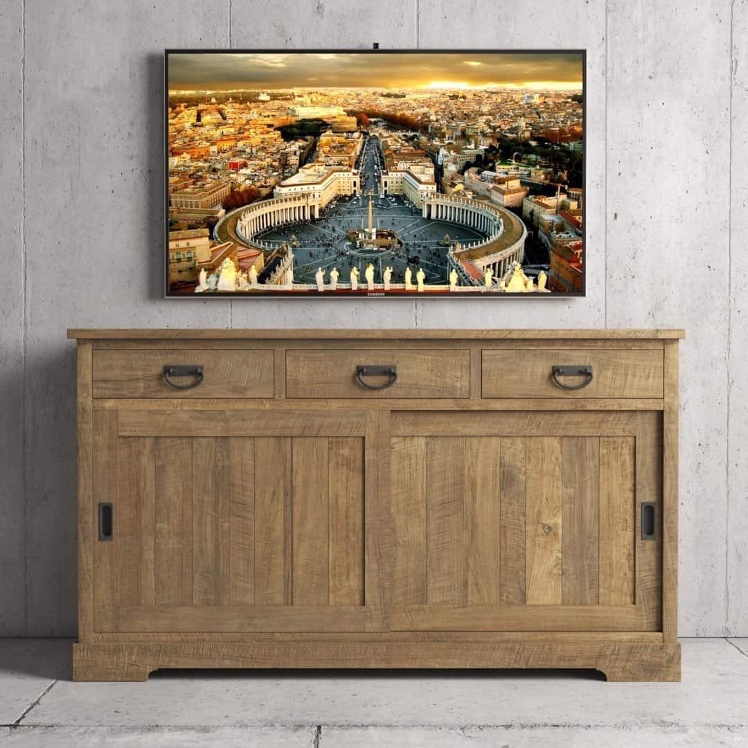 Urban Woodcraft 65 Riverbend Dining Buffet – Natural TV A flat-screen TV displaying a cityscape sits atop the Riverbend Sliding Door Dining Buffet, which features three drawers and two cabinets, against a concrete wall.