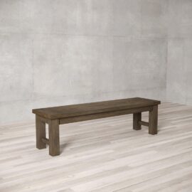 A Square Dining Bench, featuring a simple, sturdy design, is placed on a light-colored wooden floor in an empty room with gray textured walls.