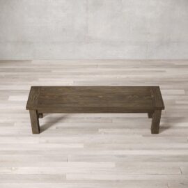 A Square Dining Bench on a light-colored wooden floor with a textured, neutral-toned wall in the background.