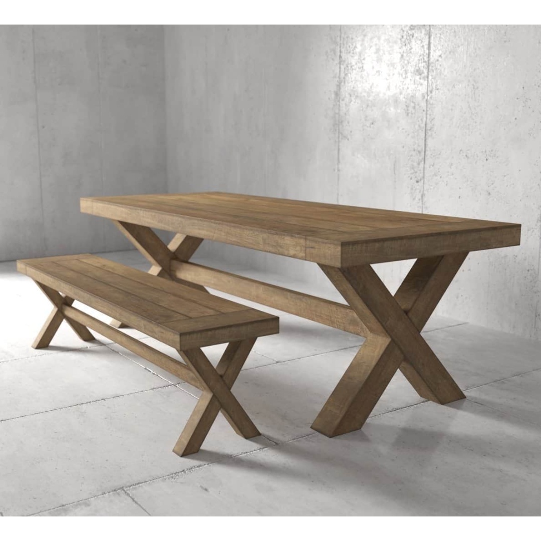 A dining set featuring the Grand X Dining Bench and an "X" shaped base wooden table, beautifully situated against a gray concrete wall and floor.