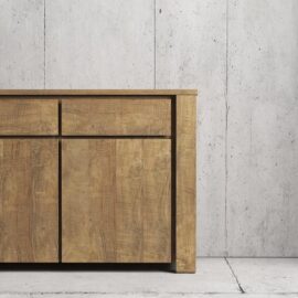 The Teca Dining Buffet, featuring three drawers and two cabinets, stands against a bare concrete wall.