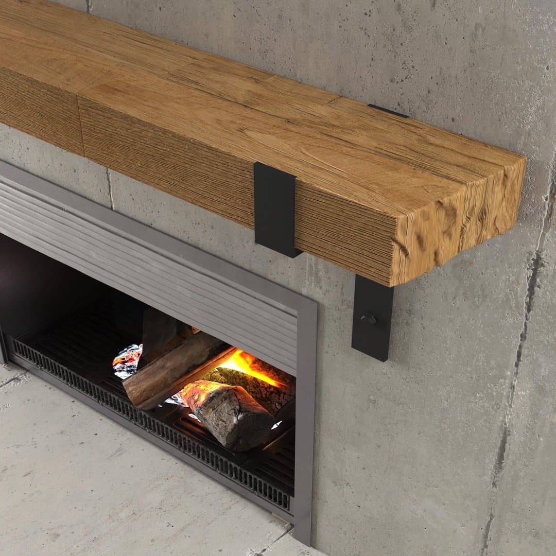 Urban Woodcraft Hudson Wall Mantel Natual (3) The Hudson Wall Mantel, with its wooden design and black metal brackets, graces the space above a lit fire against a backdrop of a concrete wall.