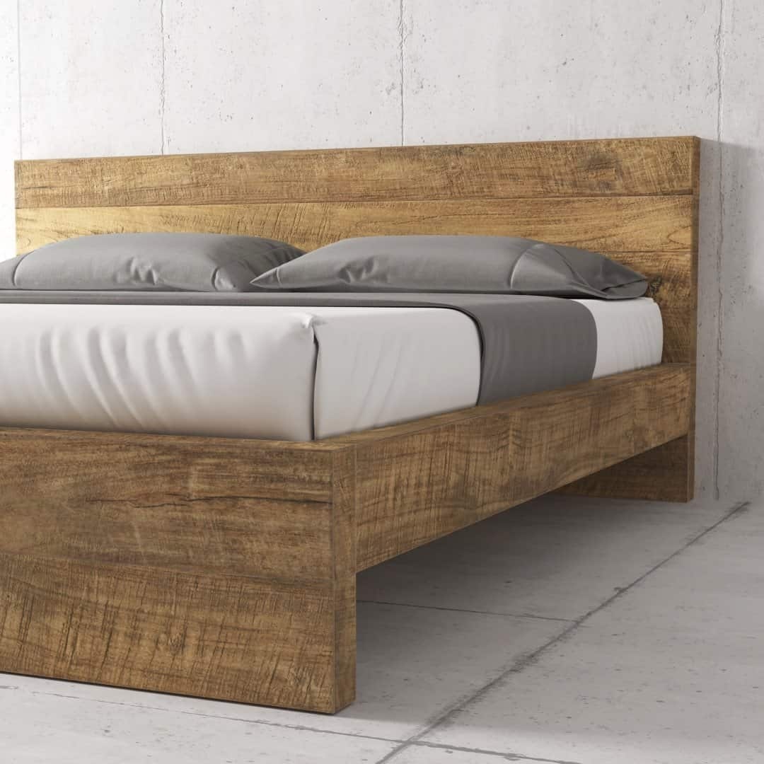 Urban Woodcraft Lugano Bed - Natural (3) The Lugano Bed, a wooden bed frame with a minimalistic design, is complemented by a grey and white bedspread and two grey pillows, set against a plain concrete wall.