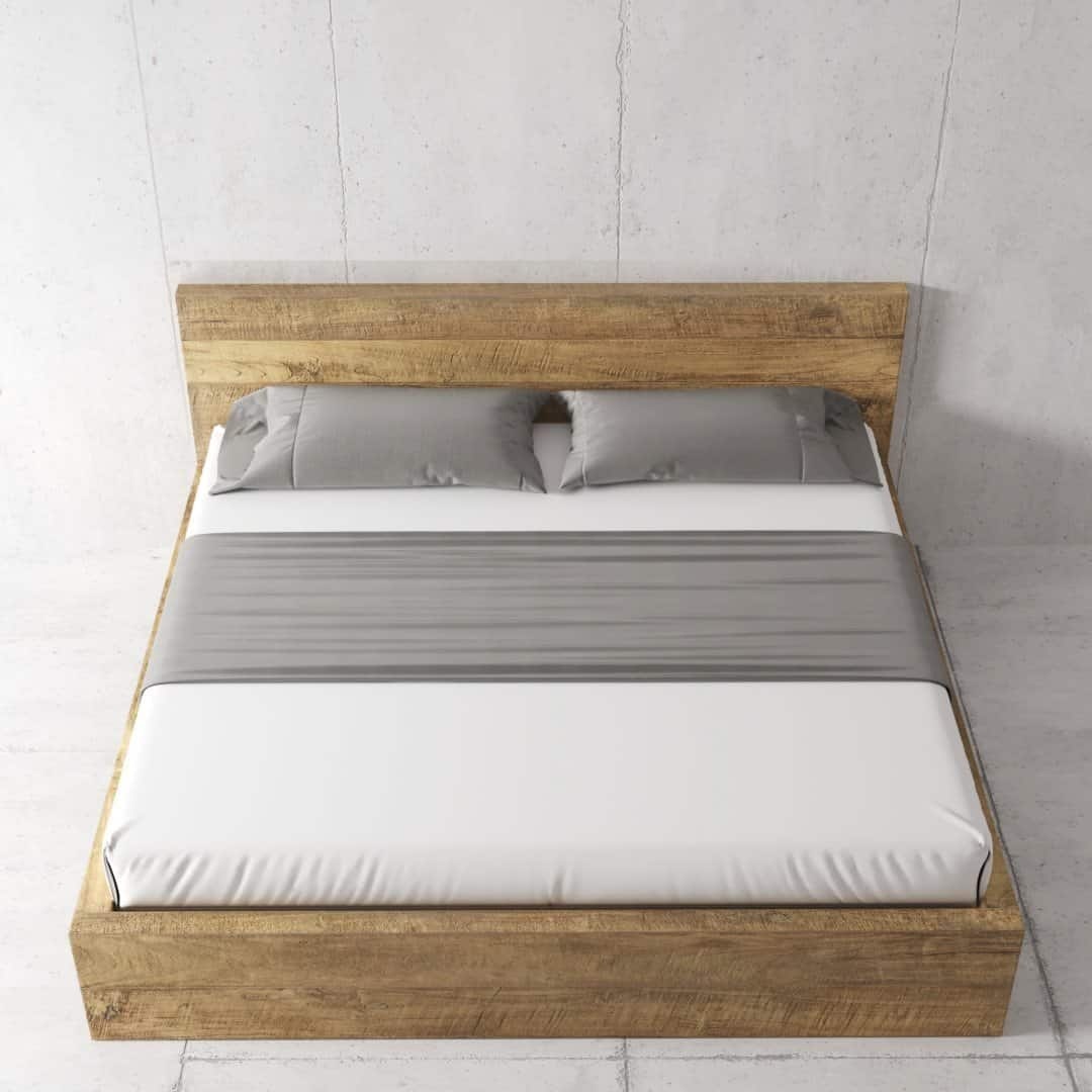 Urban Woodcraft Lugano Bed - Natural (6) A neatly made Lugano Bed with a wooden frame, adorned with white bedding, gray pillows, and a matching gray blanket, set against a plain wall.