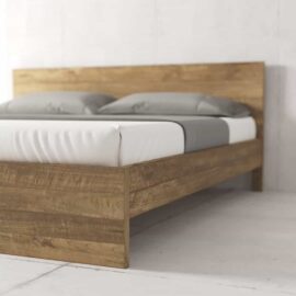 The Satillo Bed, a minimalist wooden bed frame with a high headboard, is styled with white bedding and grey pillows, set against a plain white background.