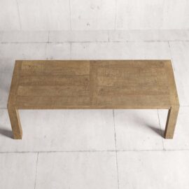 The Villa Dining Table - Natural, characterized by its long rectangular shape and simple, minimalist design, sits on a light grey tiled floor.