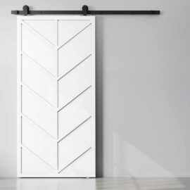 The Canal Barn Door features a white sliding design with a chevron pattern, mounted on a black metal rail, and complements the minimalist setting with light grey walls.