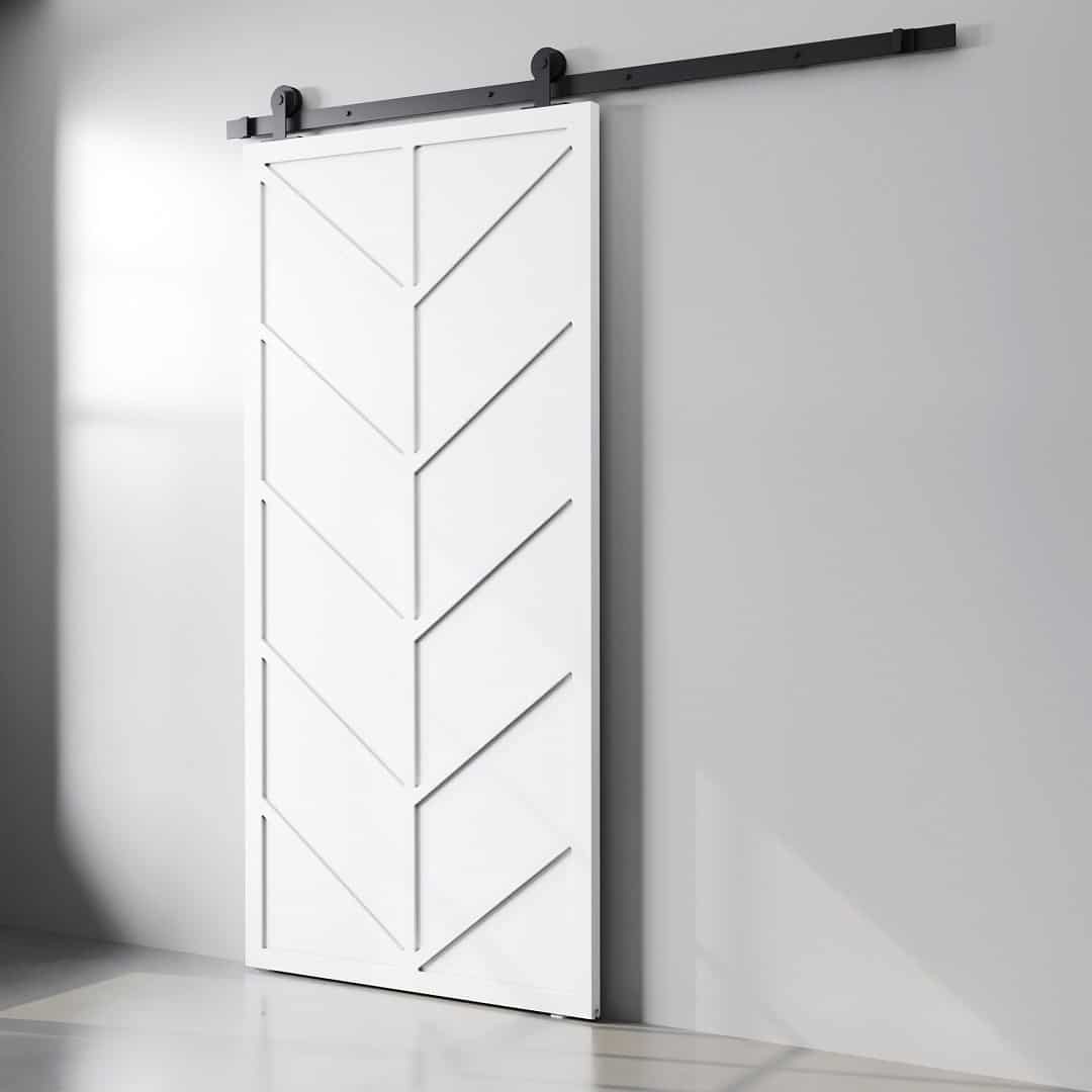 Canal Barn Door White (3) The Canal Barn Door, featuring a chevron pattern in white, is mounted on a black rail against a light gray wall.