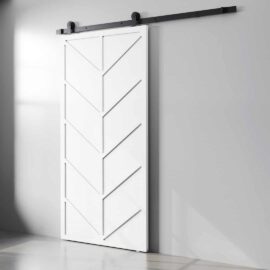 The Canal Barn Door, featuring a chevron pattern in white, is mounted on a black rail against a light gray wall.