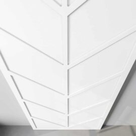 Close-up photo of the Canal Barn Door, showcasing its white geometric panel design with intersecting lines forming a chevron pattern.