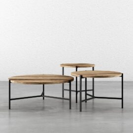 Three pieces of the 3-Piece Round Coffee Table with Star Legs, each at different heights, arranged closely together on a concrete floor against a plain white textured wall.