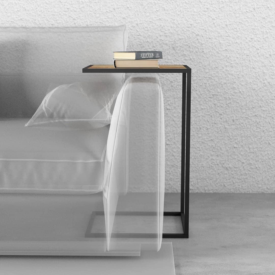 KL 023 4 TECNICO A modern Side Table featuring a black metal frame and a wooden top, placed next to a white sofa. The table holds two books and a pair of glasses.