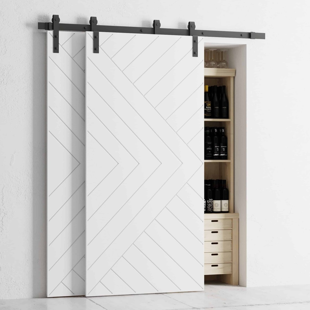The Single Track By-Pass white sliding barn doors partially cover a pantry with shelves storing bottles and drawers.