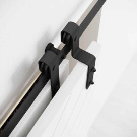 Close-up of the Single Track By-Pass black sliding door hardware attached to a white wall and door.