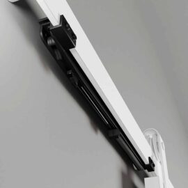 Close-up view of the Soft Close unit, a white wall-mounted retractable device with a sleek black sliding mechanism.