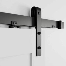 Close-up of the Soft Close black sliding barn door hardware installed on a white door, showcasing the roller mechanism and track.