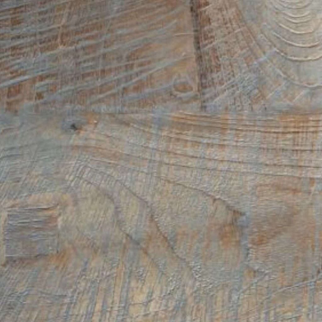 Close-up of a wooden surface showing visible grain patterns, cuts, and textures.