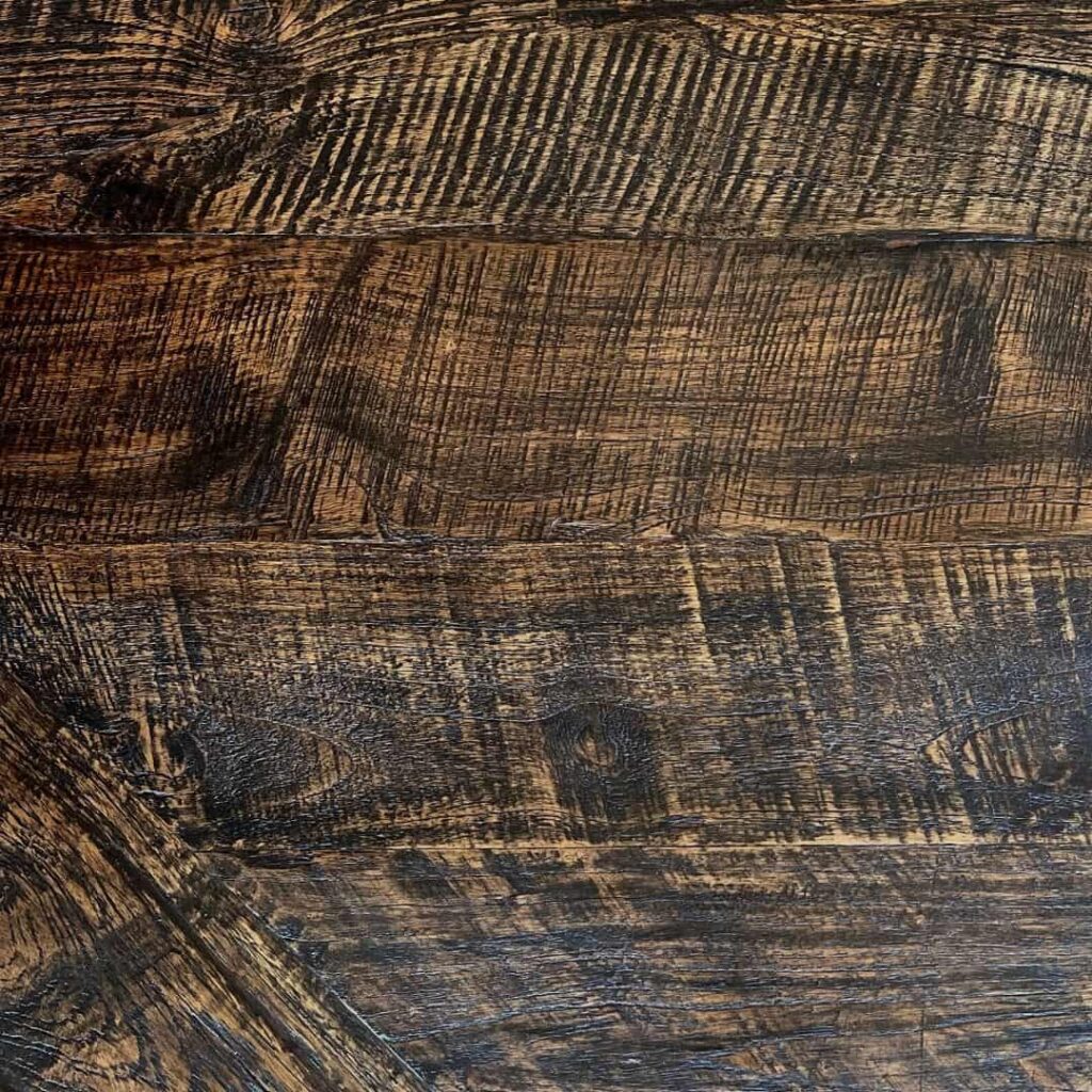 A close-up of a textured wooden surface with visible grain and dark brown hues.